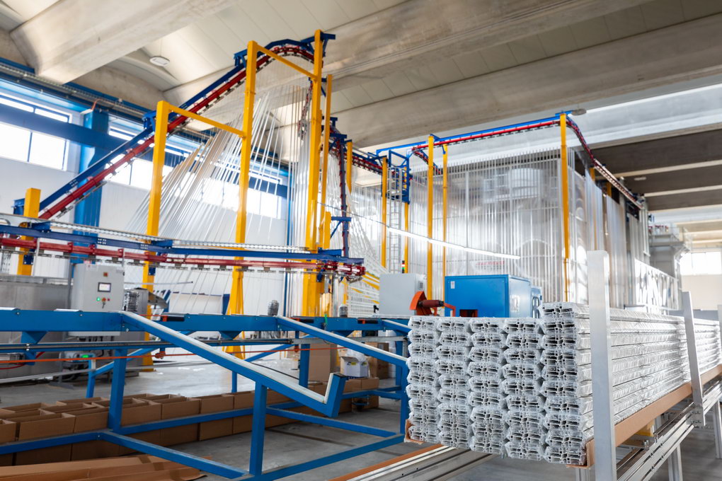 The photo shows a hook cleaning station located between the conveyor unloading and loading points